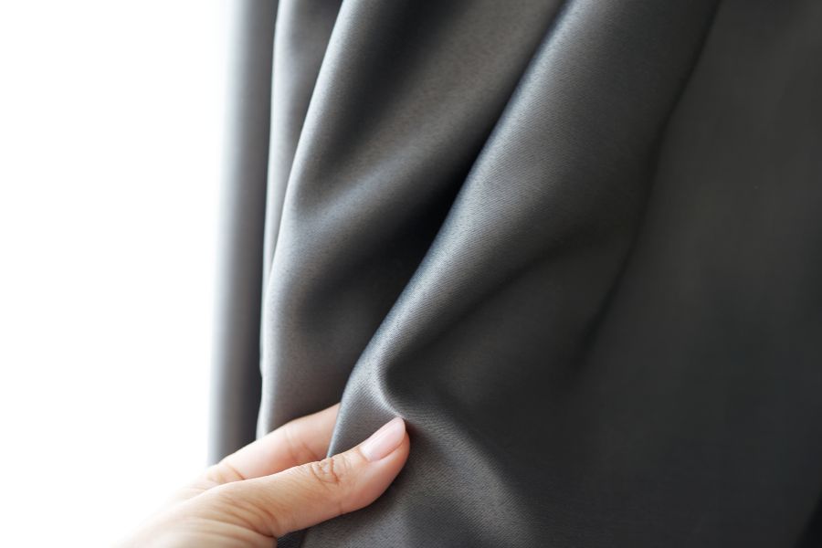 mano de mujer comprobando textura de tejido para cortinas